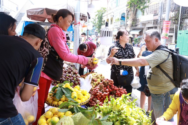 Nhiều du khách mua trái cây cho gia đình và để biếu tặng - Ảnh: VGP/Huy Phạm
